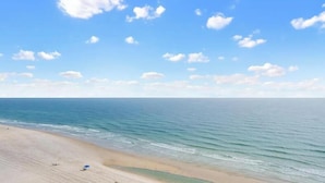 Ein Strand mit blauem Himmel und ruhiger See.