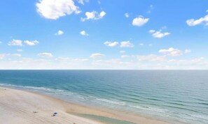 Ein Strand mit blauem Himmel und ruhiger See.