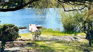 A lakeside view with a dock, a bench, and a small shed. - Vacation Home at Lake Serene (Lynnwood)