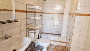 Kylpyhuone, jossa on pesuallas, wc, suihku ja pyyheteline.