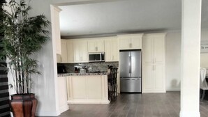 A modern kitchen with white cabinets, stainless steel appliances, and a central island. - Beautiful 4 bedroom vacation home in Punta Azul (Rosarito)