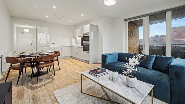 Um apartamento moderno com área de jantar, cozinha e sala de estar.