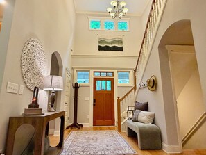 A hallway with a wooden bench, a lamp, a coat rack, and a staircase. - Luxury Home, Gorgeous Wooded Mountain Views, Pet Friendly, SLEEPS 10 (Ellijay)