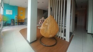 Un interior modern amb una cadira de veta, una escala i vista d'una zona de menjador.