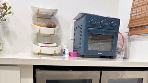 Uma cozinha com forno embutido, uma geladeira com portas de vidro e bancada branca.