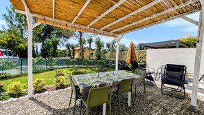 An outdoor patio with a table and chairs, a grill, and a pergola. - Sea view house with bathing establishment included for 6 people, with garden (Rosignano Solvay-Castiglioncello)