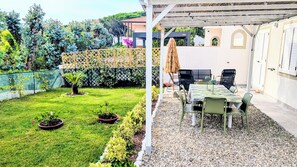 A patio with a table and chairs, surrounded by a garden with a fence and potted plants. - Sea view house with bathing establishment included for 6 people, with garden (Rosignano Solvay-Castiglioncello)