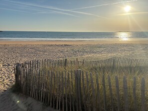 Ein Strand mit einer Holzlattenzaun, Sandstrand und dem Meer.