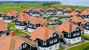 A residential area with multiple houses featuring red-tiled roofs and a mix of black and white exteriors.