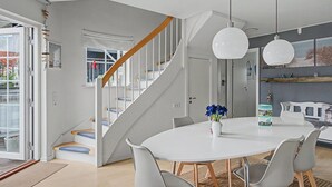 A modern interior with a staircase, a dining area, and a kitchen.