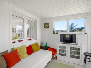 Ein Zimmer mit Bett, Fernseher, einer Vitrine, einem Fenster mit Blick und einem Spiegel.