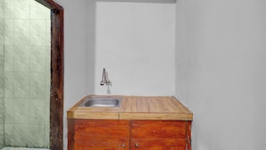 Une petite salle de bain avec un meuble-lavabo en bois, un seul évier et un mur recouvert de carreaux.
