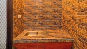 Une salle de bain avec un lavabo intégré, des murs carrelés et des meubles en bois.