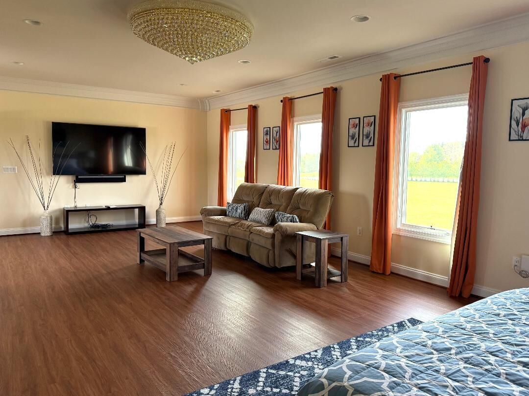A spacious living room with a sofa, coffee table, and TV.