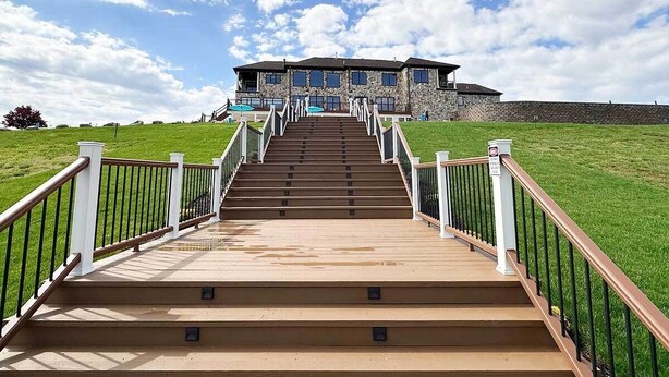A building with a staircase leading to a gated entrance, surrounded by a grassy area. - Peaceful Lakefront 1BR 1 Full Bath w/ Private Island Access & Breakfast Included (Purcellville)