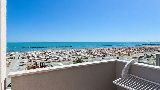 A balcony with a view of a beach with numerous umbrellas and people. - Hotel Maria Luisa (Rimini)