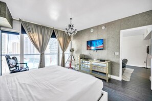 A modern bedroom with a large bed, a TV on the wall, a city view, and a balcony. - Icon Brickell - 19th Fl - Oceanview - Spa Access (Miami)