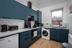 Eine moderne Küche mit Einbauwaschmaschine, Kaffeemaschine und Toaster.