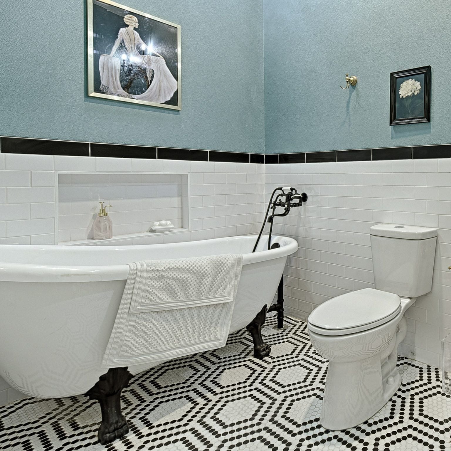 Et badeværelse med et fristående badekar, toilet og håndvask.