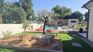 A modern outdoor patio area with a pool, seating, and a small tree. - Family villa with pool & summer kitchen  (Beaupuy)