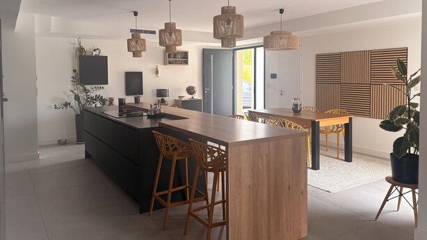 A modern kitchen with a central island, bar stools, pendant lighting, and a dining area with a wooden table and chairs. - Family villa with pool & summer kitchen  (Beaupuy)