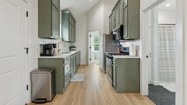 Una cucina moderna con isola centrale, elettrodomestici integrati e vista sull'area pranzo.