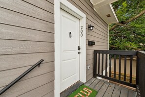 Une maison avec une porte blanche, une boîte aux lettres et le numéro « 200 » peint sur le mur.