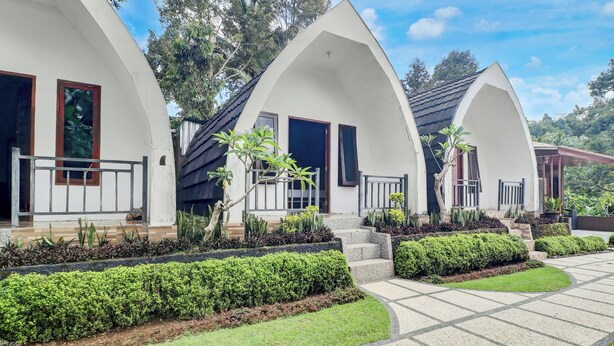A modern building with arched structures, a paved walkway, and well-maintained landscaping.