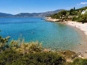 A coastal landscape with clear blue waters, a sandy beach, and rocky terrain. - Pavlos Apartment - Leontari Stay with Garden View (Leontario)