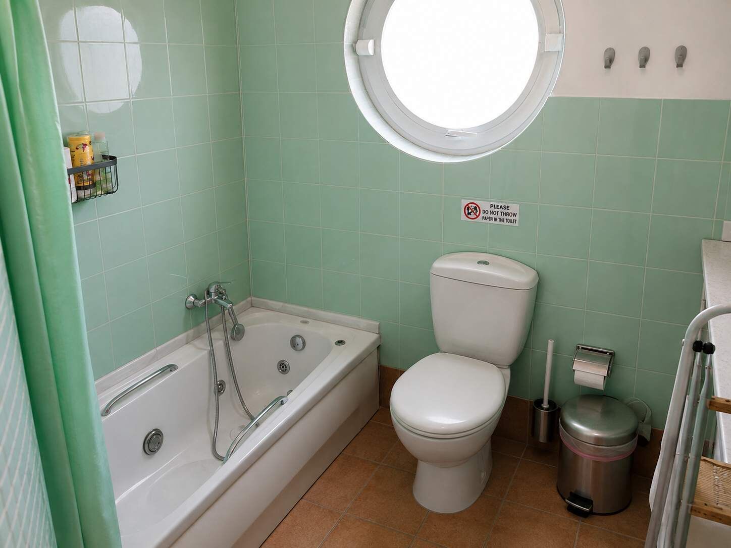 Ein Badezimmer mit Badewanne, Toilette und Mülleimer.