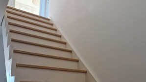 A staircase with wooden steps and white walls. - Ty cocon, quiet family home - near Gulf of Morbihan (Colpo)