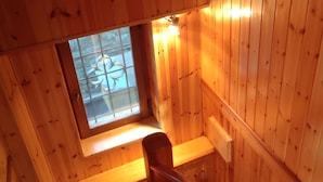 Een houten interieur met een trap die naar een klein raam leidt.