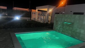 A swimming pool with a stone border and a water feature. - VILLA GREEN PARADISE GATED COMMUNITY SECURITY 24 HOURS  (puerto plata)