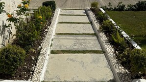 A modern building with a concrete pathway leading to a door, surrounded by well-maintained landscaping. - VILLA GREEN PARADISE GATED COMMUNITY SECURITY 24 HOURS  (puerto plata)
