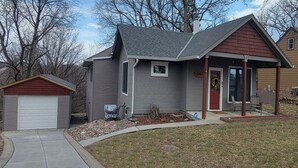A residential house with a garage, a covered porch, and a small front yard. - Forested 3/BR-Bth, patio & Lanai, movie & billiards rms, chef's kitchen,close by (Bellevue)