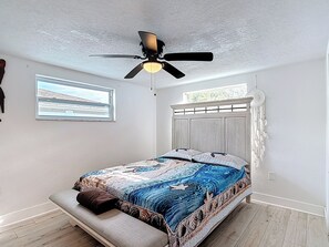 A bedroom with a bed, a ceiling fan, a window, and a wall-mounted dreamcatcher. - Gulf Breeze Retreat - Private 2BR/2BA  w/Fire Pit, Grill & Cozy Backyard. (New Port Richey)