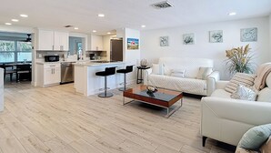 Ein modernes Wohnzimmer mit Küche, Essbereich und Sitzgelegenheit.