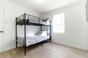 A bunk bed in a room with wooden flooring, white walls, and a window with blinds. - Modern Hemet Oasis w/ Private Pool, Gazebo & Huge Yard (Hemet)