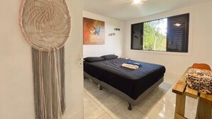 A bedroom with a bed, a ceiling fan, a window with a view, and a dreamcatcher on the wall. - At the top of Tainha beach, with a beautiful view that you can only find at Cabana do Abib. (Bombinhas)