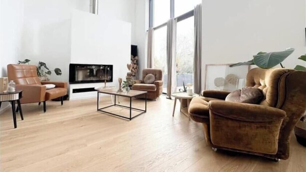Un salon spacieux doté d’une cheminée, de grandes fenêtres et d’un aménagement moderne.