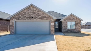 A residential house with a garage, a small attached structure, and a clear sky. - The Carlisle - 3BR/2BA - Family Friendly New Build (Lubbock)