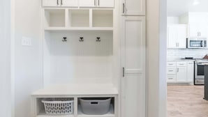 A white storage unit with shelves, hooks, and baskets. - The Carlisle - 3BR/2BA - Family Friendly New Build (Lubbock)