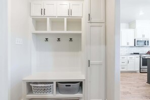 A white storage unit with shelves, hooks, and baskets. - The Carlisle - 3BR/2BA - Family Friendly New Build (Lubbock)