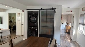 Eine moderne Küche mit einer zentralen Kochinsel, eingebauten Geräten und einem Essbereich mit Holztisch und Stühlen.