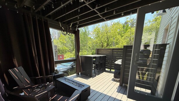 Eine Terrassenausstattung im Freien mit Grill, Sitzgelegenheit und Blick auf die umliegende Natur.