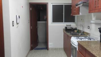 A kitchen with a stove, sink, and cabinets.