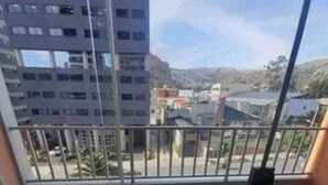 Een balkon met uitzicht op gebouwen en een heldere lucht.
