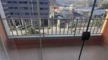 A balcony with a view of buildings and a clear sky.