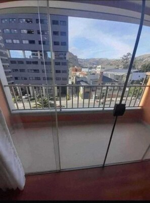 Un balcone con vista su edifici e un cielo sereno.