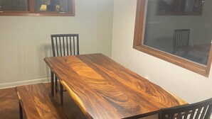 Un comedor con mesa de madera, bancos y sillas.